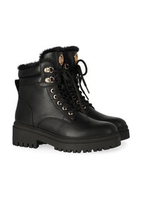 Zwarte leren enkellaarsjes met een zachte bontkraag, gouden hardwareaccenten en een stevige rubberen zool met diepe profielen. Geknoopd ontwerp voor een stevige pasvorm.