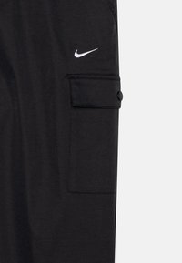 Črne cargo hlače z stranskim žepom in detajlom z gumbom, z belim logotipom Nike swoosh. Gladka tekstura tkanine in prileganje po meri.