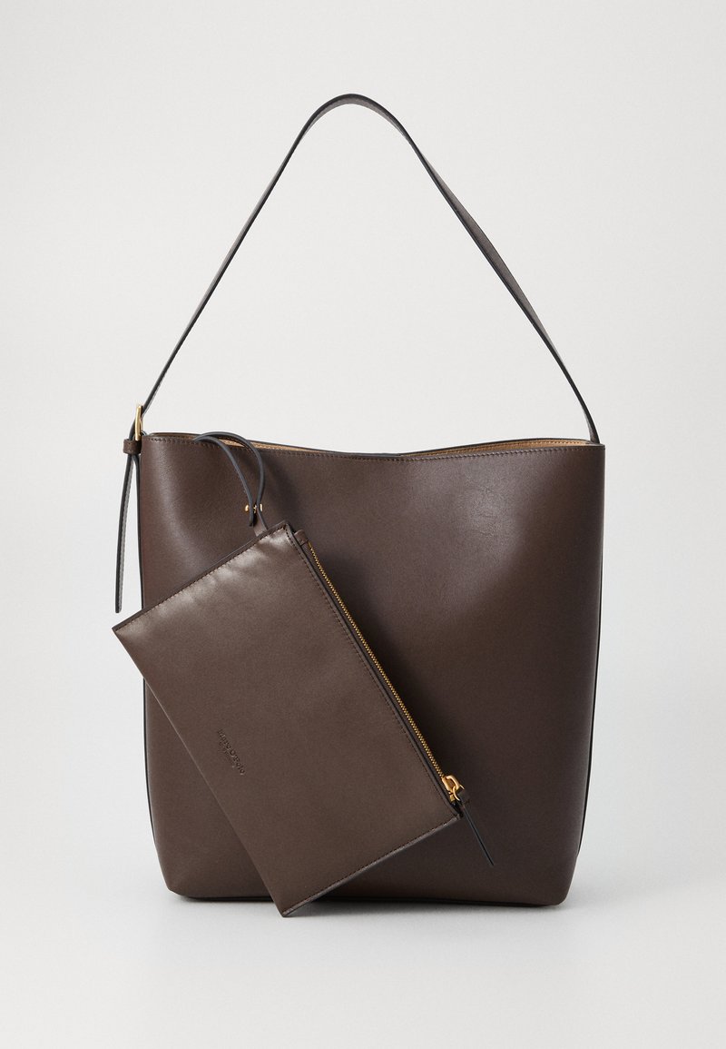 Braune Leder-Tote-Bag mit einem strukturierten Körper, einer schmalen Reißverschlusstasche und einem einzigen Schultergurt. Glatte Textur, minimalistisches Design.