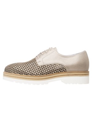 Beige snørestøvle i oxford-stil med perforeret tå og sider, lysebrun mellemsål og hvid ydersål, vist fra ydersiden.