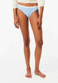 Lichtblauwe katoenen ondergoed in bikini-stijl met een witte elastische tailleband waarop de merknaam herhaald langs de rand is gedrukt.