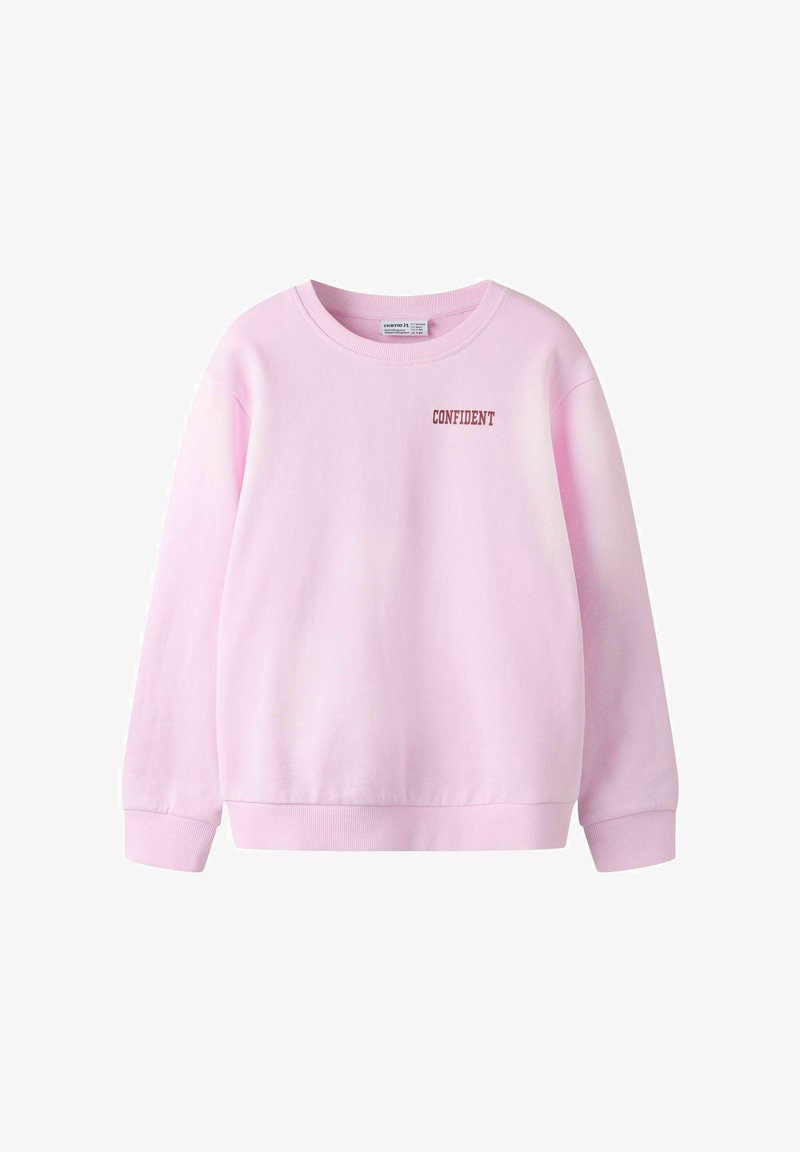 Svijetloružičasti duks s okruglim izrezom i dugim rukavima, s malim smeđim slovima "CONFIDENT" ispisanim na lijevoj strani prsa.