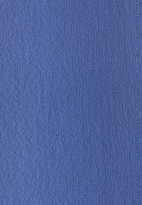 Tissu bleu avec un motif tissé finement texturé, créant des lignes diagonales et ondulées subtiles à travers la surface.