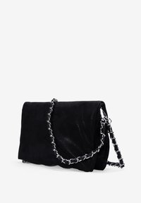 Bolso de mano de imitación cuero negro con un acabado texturizado, forma rectangular y correa de cadena plateada. Cuenta con un cierre de solapa y bordes suaves.