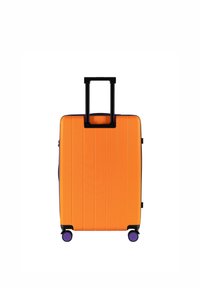 Walizka o twardej skorupie w jaskrawym pomarańczowym kolorze z pionowymi rowkami, wysuwanym czarnym uchwytem i fioletowymi kółkami. Kompaktowy design idealny do podróży.