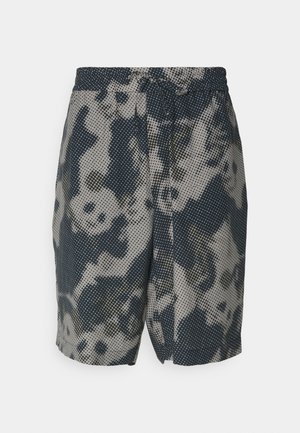 Shorts avec un motif bleu foncé et beige, présentant un design à pois. Ceinture élastique avec cordon de serrage, longueur genou, en tissu léger.