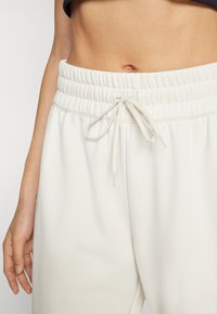New Balance WARMING PERFORMANCE JOGGER - Jogginghose - offwhite