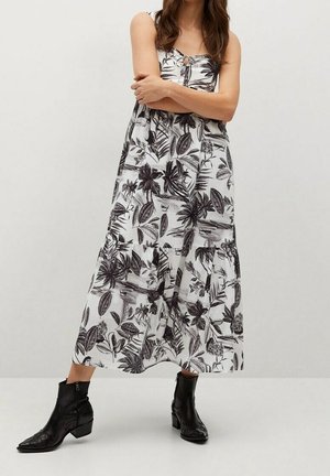 Midikleid mit Blumenmuster in Schwarz und Weiß, das eine Knopfleiste vorne und verstellbare Schulterträger hat. Der Stoff ist leicht.