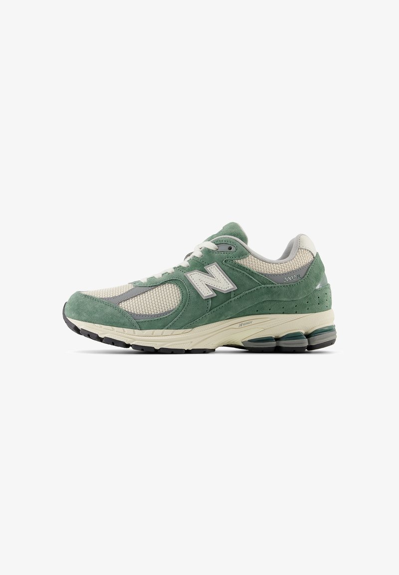 Green and beige athletic shoe featuring a suede and mesh upper, with a cushioned sole, prominent branding, and grey accents.