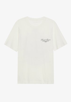 Camiseta de algodón blanca con cuello redondo y mangas cortas, que presenta un detalle en texto negro en el lado izquierdo del pecho. Textura suave y corte casual.