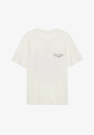 White cotton t-shirt with a round neckline and short sleeves, featuring black text detailing on the left chest. Soft texture and casual fit.