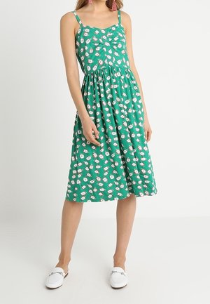 Grünes ärmelloses Kleid mit Blumenmuster, tailliertem Oberteil und gerafftem Rock. Glatter Stoff mit mittellangem Schnitt und lässigem Design.