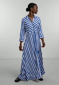 Vestido longo, abotoado, em listras verticais azuis e brancas. Tecido leve, com colarinho e mangas até o pulso. Textura suave.
