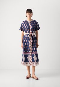 Mørkeblå kjole med korte ermer, blomster mønstre i rødt og hvitt, belte i midjen og dekorative kanter. Midje lengde design. Glatt stoff.