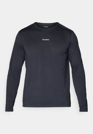 Long-sleeve, navy blue athletic shirt made of lightweight, breathable fabric with a textured finish and a small white logo on the chest.