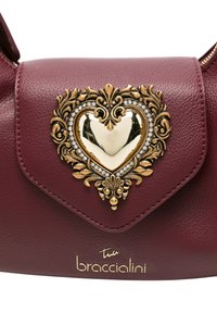 Borsa a mano in pelle color mogano con chiusura a forma di cuore dorato, decorata con dettagli ornamentali e accenti di cristallo. Logo Braccialini impresso sul davanti.