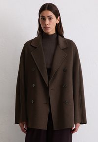 Brauner Wollmischung, doppelt geknöpfter Mantel mit großen Reverskragen, zwei Fronttaschen und grünen Knöpfen, der eine lässige Silhouette bietet.