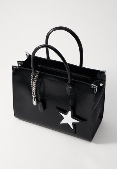 Sac fourre-tout en cuir noir avec un design en étoile, ferrures en chaîne argentée et poignées supérieures. Comprend une fermeture à glissière et une texture brillante.