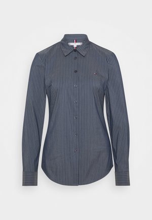 Dunkelgraues, langärmliges Hemd mit Knöpfen, weißen vertikalen Nadelstreifen, einem Kragen und einem kleinen gestickten Logo auf der linken Brust.