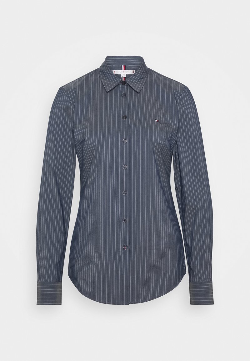 Chemise gris foncé à manches longues avec boutons, rayures blanches verticales, col et petit logo brodé sur la poitrine gauche.