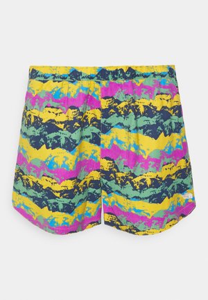 Short multicolored shorts with an abstract mountain pattern in yellow, pink, green, blue, and black, featuring an elastic waistband and logo on hem.