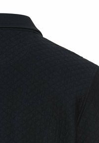 Black quilted polo shirt featuring a textured surface and a classic collar design. The material appears soft and comfortable.