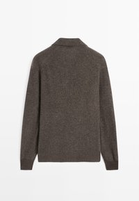 Pull en tricot marron foncé avec une texture côtelée. Doté d'un col et de manches longues, avec un design sans coutures et des poignets côtelés.