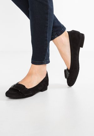 Bailarinas de ante negro con detalle de lazo y adorno de hebilla, con un tacón bajo y plano y una textura de superficie suave.