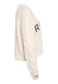 Nertinis kreminės spalvos megztinis su tekstūruotu kabelių raštu, turintis trumpą dizainą ir ryškų juodą raidę "R" priekyje.