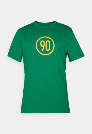 Camiseta de algodón verde con un logo amarillo redondo que tiene el número "90" en el centro. Cuello redondo clásico y mangas cortas.