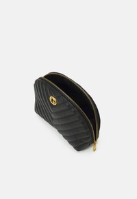 Pochette nera in pelle con zip, dotata di texture trapuntata, hardware dorato e un accent oval logo. Leggermente aperta per rivelare un interno vuoto.