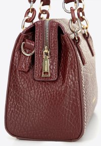 Ciemnoczerwony skórzany torebka o strukturalnym wykończeniu, ze złotymi akcesoriami i zamknięciem na zamek. Posiada masywny łańcuch jako pasek oraz szczegółowe przeszycia.