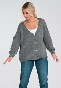 Szary dzianinowy kardigan z dekoltem w serek, w luźnym fasonie, z długimi rękawami i pięcioma brązowymi guzikami z przodu. Miękka faktura i swobodny krój.