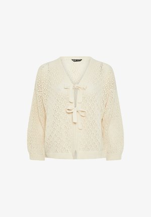 Gebreide cardigan in crèmekleur met een V-hals, opengewerkte patronen en striksluiting in de taille. Beschikt over lange, losvallende mouwen.