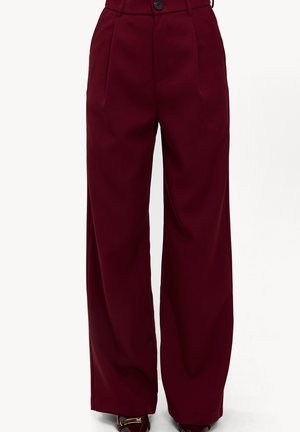 Pantalon large bordeaux taille haute, avec une fermeture à un bouton, des plis à l'avant et une texture lisse.
