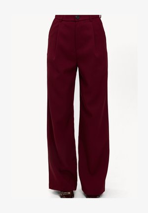 Pantalon large bordeaux taille haute, avec une fermeture à un bouton, des plis à l'avant et une texture lisse.