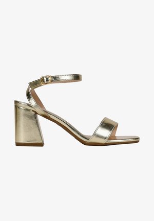 Gold metallic high-heeled sandal with a block heel. Features a single strap across the toes and an ankle strap with a buckle.