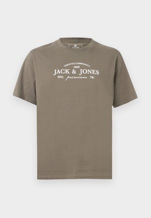 T-shirt marron à manches courtes avec texte blanc "JACK & JONES" et marquage "creative community 1990" sur la poitrine, col rond.