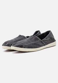 Scarpe slip-on grigie in tela con superiore testurizzato, suola in gomma bianca e design minimalista. Senza marchi o decorazioni visibili.