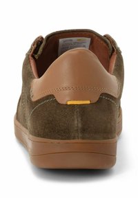 Brune ruskinds sneakers med en tan læder hælkrave, gummisål og gule detaljer nær bagenden. Blødt overdel og sydde detaljer.