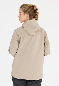 Vaaleanbeige vedenpitävä takki, jossa on huppu, rento istuvuus, pitkät hihat ja sileä pinta, sopii ulkoilutoimintoihin.