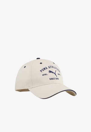 Beige Puma Athletics honkbalpet met zwart logo en tekst, gebogen klep met zwarte randdetail.