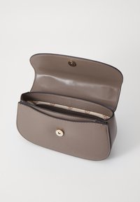 Borsa a tracolla in pelle di luce grigia con una texture liscia, forma curvilinea e accessori in oro. L'interno presenta una fodera in tessuto a motivo e scomparti.