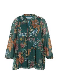 Blouse verte à manches longues avec motif floral marron et rose, ourlet volanté et détail à nouer au col sur fond blanc.