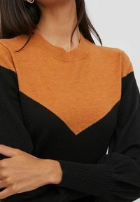 Maglione color block nero e arancione con design a zigzag, texture lavorata a maglia, colletto a coste e maniche a sbuffo.