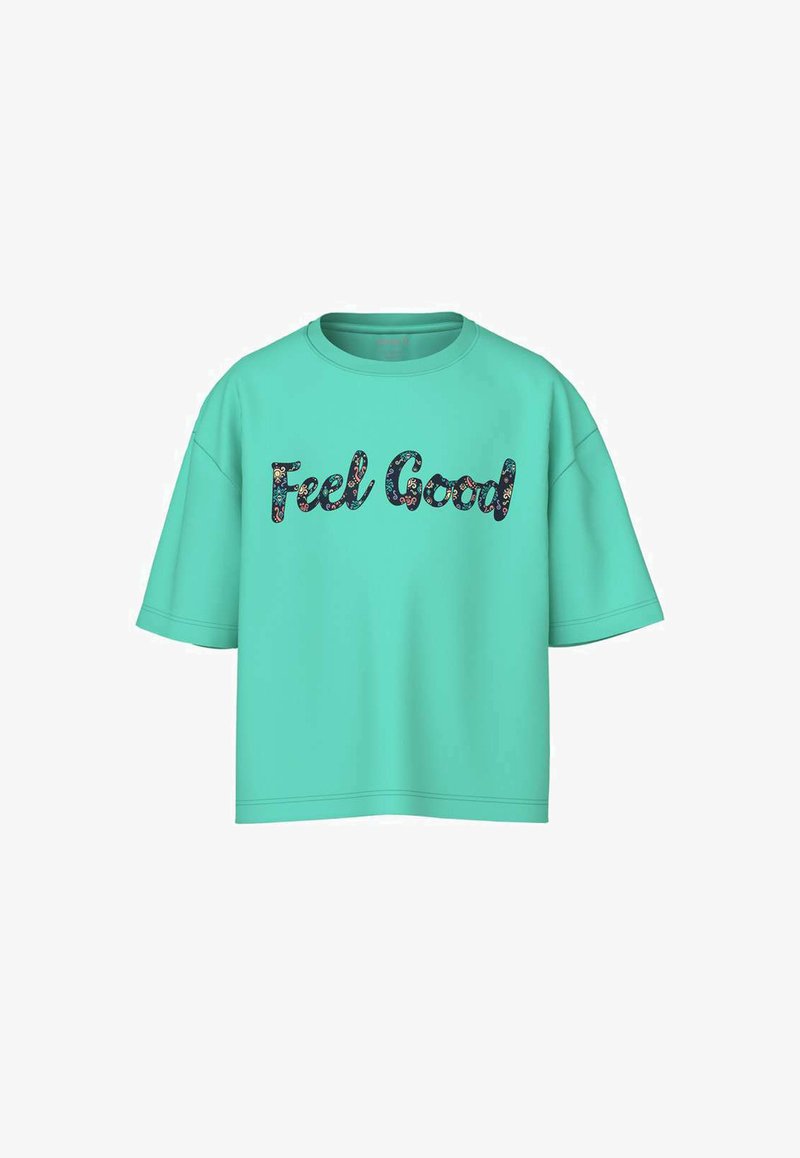 T-shirt surdimensionné à manches courtes couleur turquoise avec le texte « Feel Good » en lettres à motif floral sombre centré sur le devant.