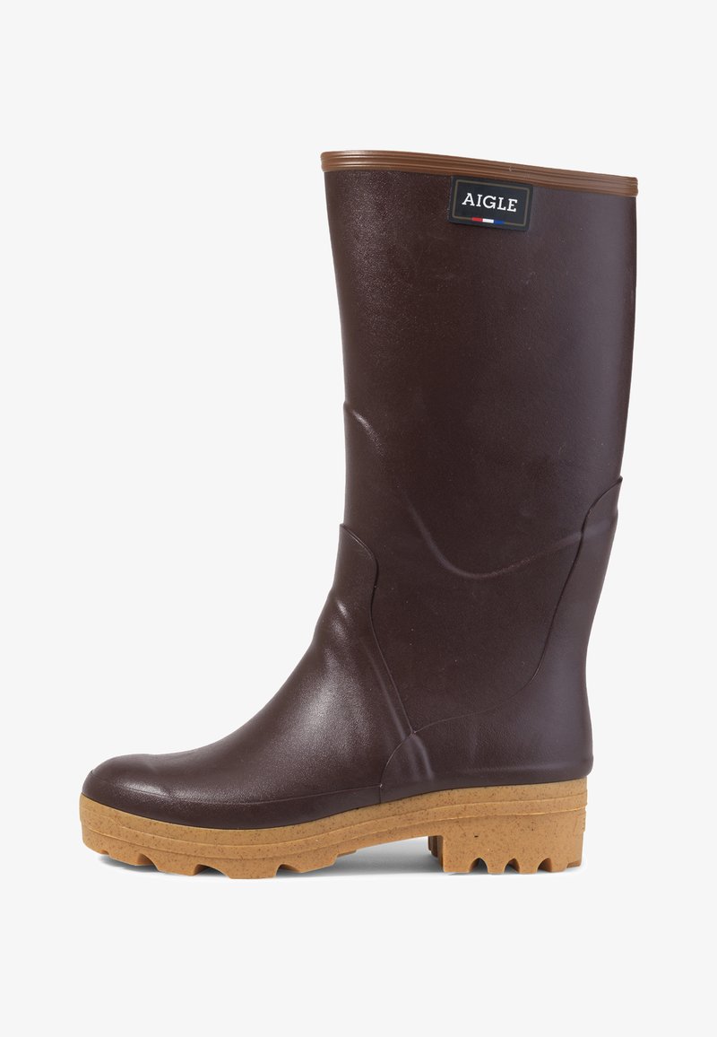 Botte de pluie en caoutchouc marron avec une finition texturée, contour marron en haut et semelle marron contrastante avec des motifs de traction prononcés.