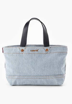 Bolso tote de Levi's con rayas azules y blancas, asas de cuero negro y costuras marrones sobre un fondo blanco.