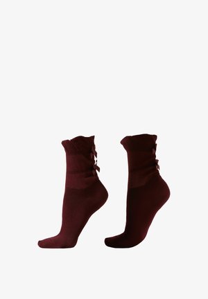 Chaussettes bordeaux avec un ourlet côtelé, ornées de petits nœuds assortis sur les côtés. Fabriquées en matériau doux, avec une texture lisse.