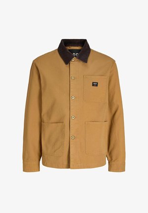 Ruda užsegama striukė su tamsios spalvos korduro stovu ir trimis priekinių kišenių lopais, iš kurių vienoje yra maža juoda etiketė su užrašu „R.D.D.“.